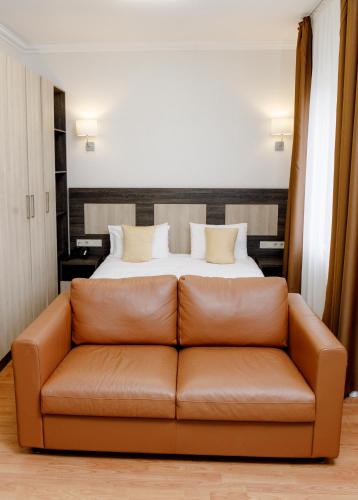 a living room with a couch in front of a bed at INFINITY PLAZA BLOCK 1 in Atyraū