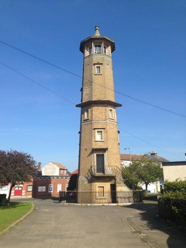 a tall brick tower with a fence around it at The Bakehouse in Harwich