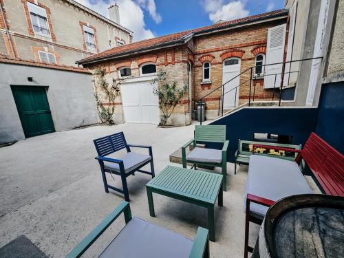 un groupe de bancs colorés assis devant un bâtiment dans l'établissement Villa - centre d'Epernay - 6 Chambres - Terrasse, à Épernay