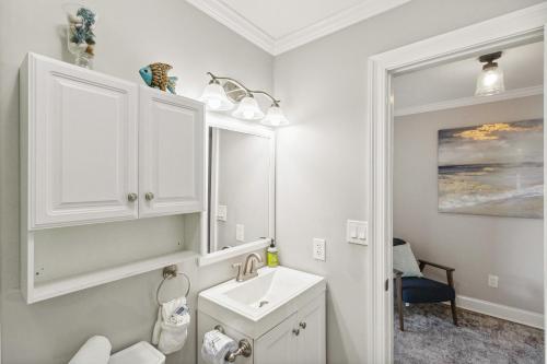 un bagno bianco con lavandino e specchio di Good Times and Tan Lines a Saint Joe Beach