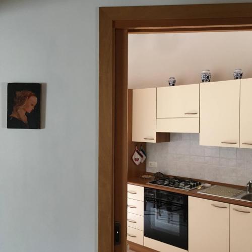 a kitchen with white cabinets and a stove top oven at Casa di Nonno Tilio in Priola