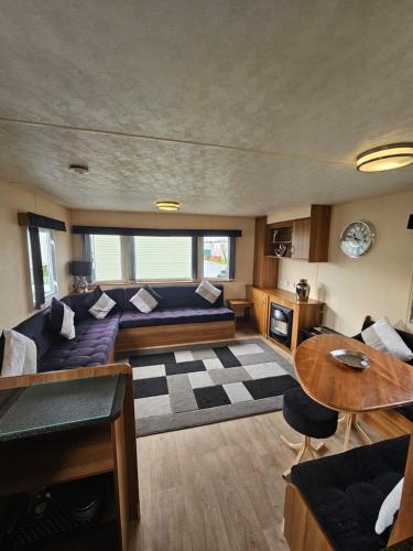 a living room with a couch and a table at Golden Sands 8 berth cosy caravan in Rhyl