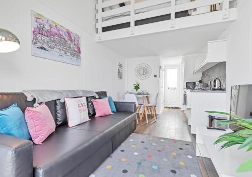 a living room with a gray couch with pink and blue pillows at On the Water 3 A One-of-a-Kind Stay Free Parking By My Getaways in Brighton & Hove