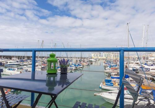 a table on a balcony with boats in a marina at On the Water 3 with Free Parking By My Getaways in Brighton & Hove
