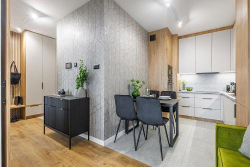 a kitchen with a table and chairs in a room at Emihouse Riverside Business Apartment in the Heart of Rzeszów in Rzeszów