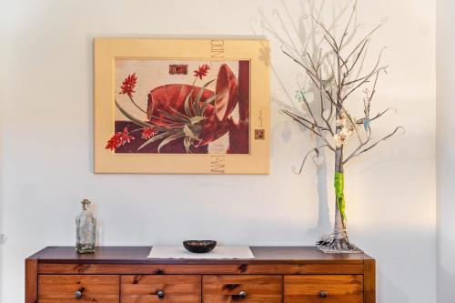 a vase on a wooden cabinet with a picture on the wall at Ferienwohnung - Wolkow in Wolkow