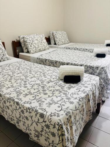 a room with three beds and a couch at Hotel Rainha do Sertão By Lmm in Quixadá