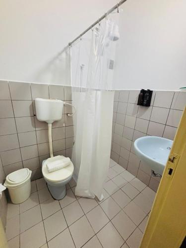 a bathroom with a toilet and a sink at Hotel Rainha do Sertão By Lmm in Quixadá