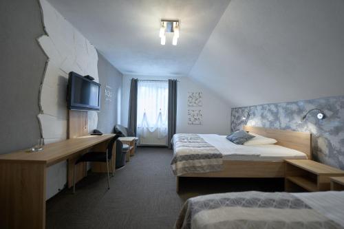 a hotel room with two beds and a desk at Penzion Sankt Johann in Liptovský Ján