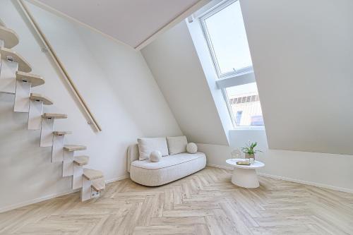 un soggiorno bianco con sedia e scale di Amazing apartments 2 x free parking x 24x7 a Vilnius