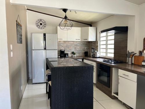 a kitchen with white cabinets and a black counter top at Maison Cambuston in Saint-André