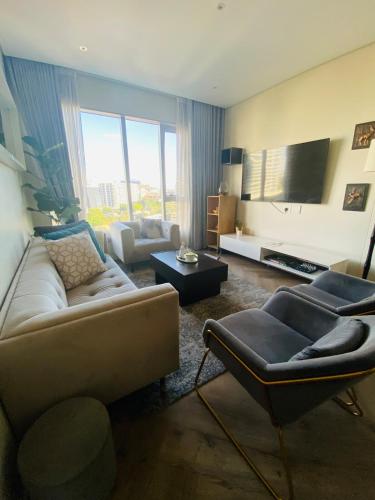 a living room with a couch and a tv at Cosy Uptown 2 Bedroom Sandton in Johannesburg