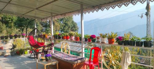 balcone con sedie, tavolo e piante in vaso di Namo Homestay a Sosing