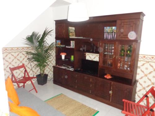 - un salon avec un grand centre de divertissement en bois dans l'établissement Casa da Turquinia, à Palmela