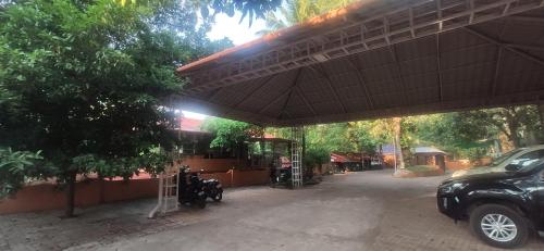 a building with a motorcycle parked under a canopy at Dhyana Bindhu Home Stay in Kollam