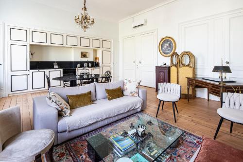 un salon avec un canapé et une table dans l'établissement Élégance et Luxe au Cœur de Bordeaux-Quinconces, à Bordeaux