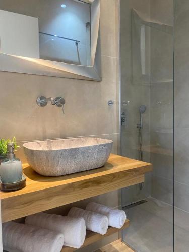 a bathroom with a sink and a glass shower at Villa Marion in Chrysi Ammoudia