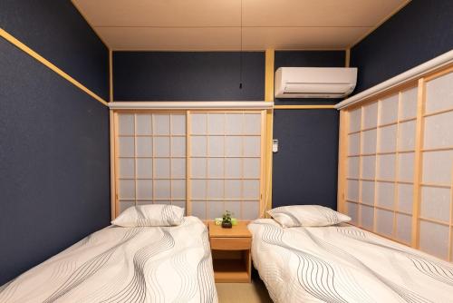 Y's INN MaisonRose 106T في طوكيو: غرفه فيها سريرين وسخان