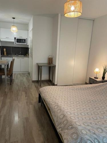 une chambre avec un lit et une table et une cuisine dans l'établissement Elegant studio with pool in Aix-en-Provence, à Éguilles