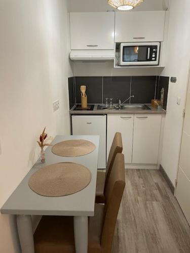 une petite cuisine avec une table et un micro-ondes dans l'établissement Elegant studio with pool in Aix-en-Provence, à Éguilles