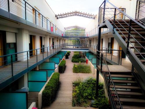 un couloir vide d'un immeuble avec des escaliers et des plantes dans l'établissement Elegant studio with pool in Aix-en-Provence, à Éguilles