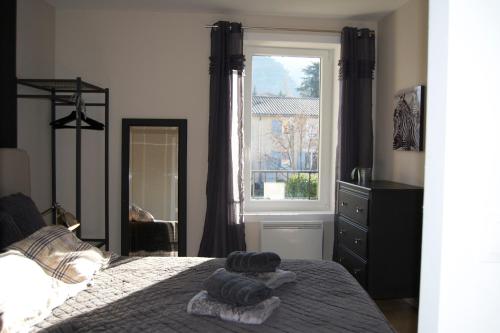 a bedroom with a bed with two towels on it at Appart'hôtel 27 le lion d'or in Malaucène