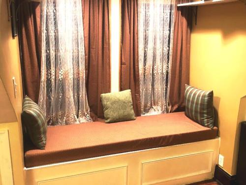 a bench with two pillows sitting in a window at Quaint 3rd Floor Loft in Highland Park