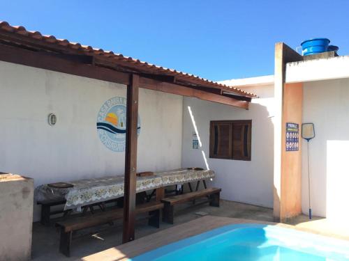 a patio with benches next to a swimming pool at Casa por temporada Barra Nova in Marechal Deodoro