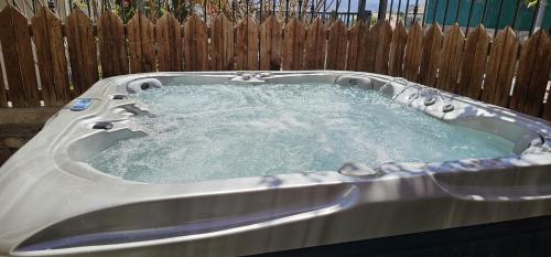 a hot tub with water in front of a wooden fence at Amdar Holiday Apartments in Eilat