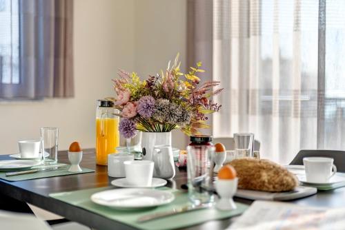 a dining table with a vase of flowers on it at Apartment B10 "Südbalkon mit Haffblick" im Pine Hill Resort in Zirchow