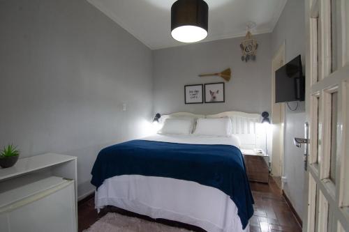a bedroom with a large bed with a blue blanket at Happiness House Hospedagem in Cuiabá