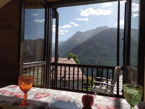 a table with a view of mountains from a balcony at Oasi di Pace vicino Sestriere in Champlas du Col