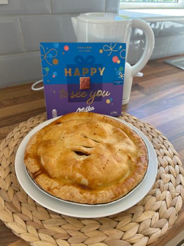 a pie on a plate on a table with a happy to see you with at The Perfect Place in Ennis