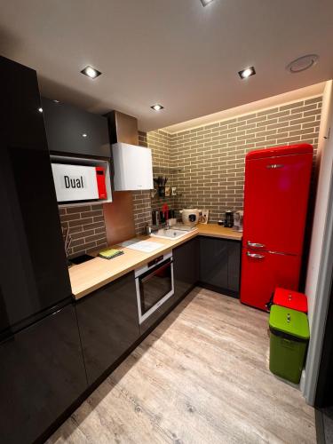 La cuisine est équipée d'un réfrigérateur rouge. dans l'établissement Aux 2 Lièvres, à Riom-ès-Montagnes