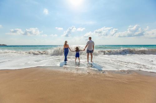 a family standing in the water on the beach at Апартаменти Амфора in Pomorie