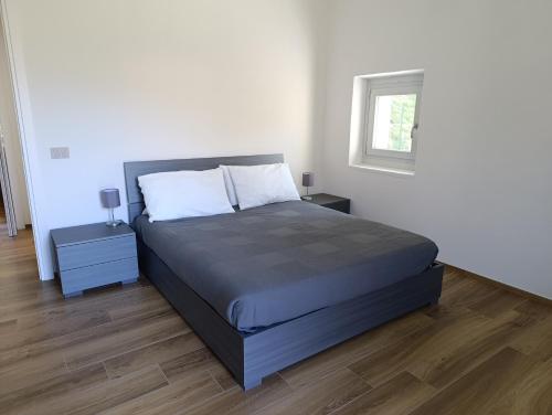 a bedroom with a large bed and a window at Ema Home - nature and Lake Como - Argegno in Dizzasco