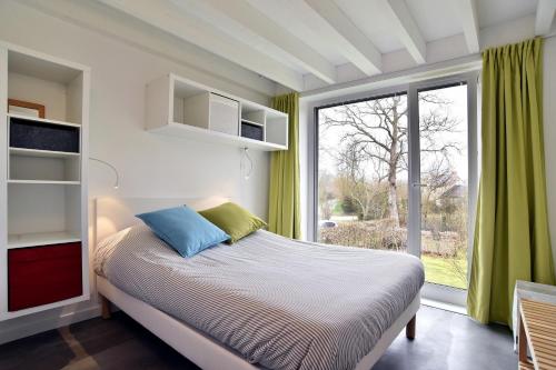 une chambre avec un lit et une grande fenêtre dans l'établissement Belle Ville - Maison lumineuse, cadre verdoyant, à Saint-Briac-sur-Mer