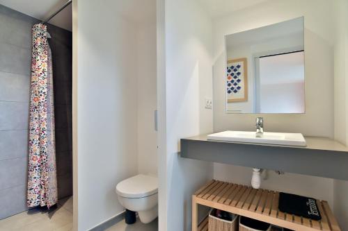 une salle de bain avec un lavabo et des toilettes dans l'établissement Belle Ville - Maison lumineuse, cadre verdoyant, à Saint-Briac-sur-Mer