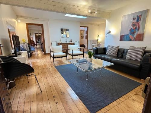 un salon avec un canapé noir et une table dans l'établissement La Tour Croix Baragnon, à Toulouse