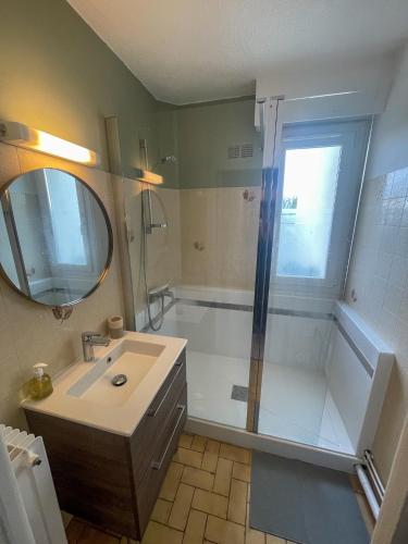 une salle de bain avec une douche, un lavabo et un miroir dans l'établissement T2 paisible et lumineux proche tram B, à Talence