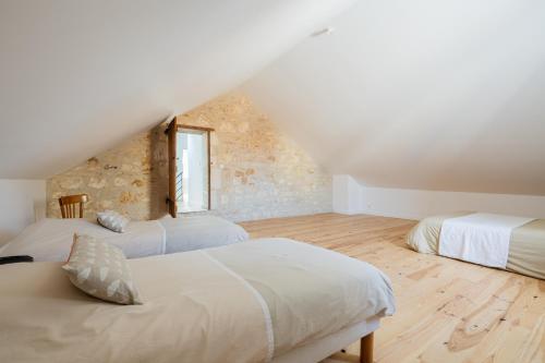 - une chambre mansardée avec 2 lits et une fenêtre dans l'établissement Belle villa rénovée aux portes de l'île d'Oléron, à Bourcefranc