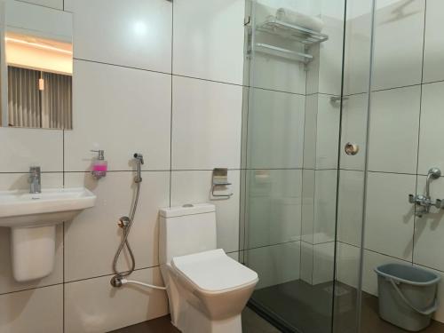 a bathroom with a toilet and a shower and a sink at Sandcastle Resort in Varkala