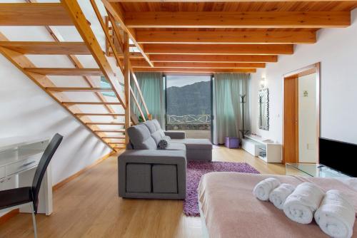 a room with a bed and a couch and a tv at Refugio Da Xamusca in São Vicente