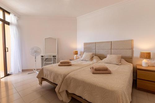 a bedroom with a large bed with two towels on it at Sunset Flower Apt By Dream Homes Tenerife in Puerto de Santiago