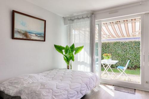 une chambre avec un lit et une grande fenêtre dans l'établissement Appartement cosy 2 personnes - Sarzeau, à Sarzeau