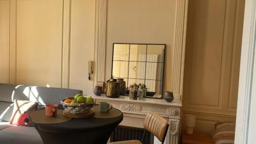 un soggiorno con tavolo e cesto di frutta di Appartement charmant à Les Andelys - 36 m² avec jardin a Les Andelys