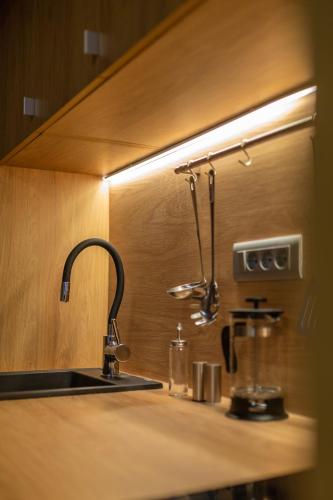 a kitchen counter with a sink and a light above it at Studio Suites Mila in Komiža