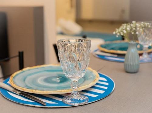 a table with two plates and a wine glass on it at Apart-hotel Cantinho da Serra in Nova Friburgo