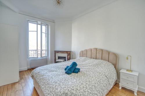 - une chambre dotée d'un lit avec un objet bleu dans l'établissement Elegance Versaillaise, à Versailles