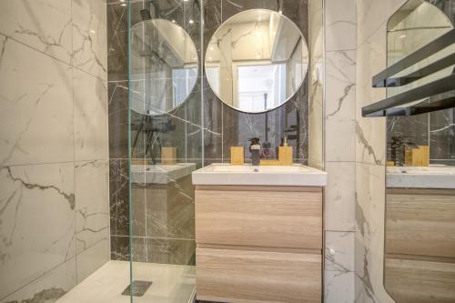 une salle de bain avec un lavabo et un miroir dans l'établissement Elegance Versaillaise, à Versailles